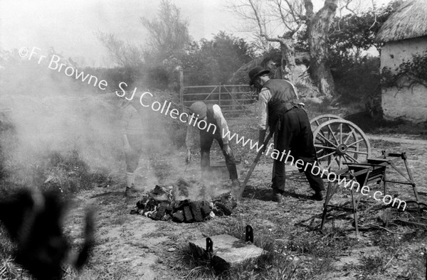 FORGE : SHOEING A WHEEL IN OLDEN STYLE : ON RIGHT A COOLING TANK USED IN MAKING PIKES IN '98